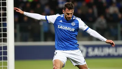 A photorealistic image of an anonymous Le Mans FC player, aged 25-30, wearing a blue jersey with white sleeves and white...