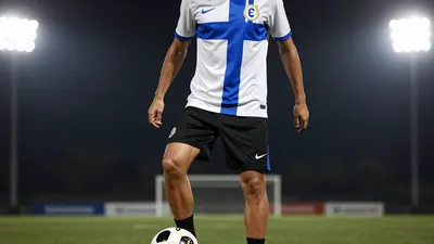 A photorealistic image of an anonymous Le Mans FC player in a white jersey with a blue stripe, wearing a pair of black...