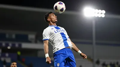 A photorealistic image of a Le Mans FC player, wearing a white jersey with a blue stripe and blue shorts, in mid-air as...